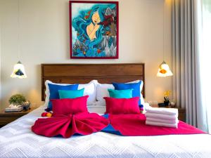 a bedroom with a bed with red and blue pillows at Casa La Aurora - Beachfront Studio and Rooftop Infinity Pool in Puerto Morelos
