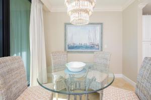 a dining room with a glass table and chairs at Phoenix on the Bay 1206 in Orange Beach