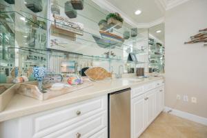 a kitchen with a sink and glass wall at Phoenix on the Bay 1206 in Orange Beach