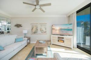 a living room with a couch and a flat screen tv at Phoenix on the Bay 1206 in Orange Beach +42 photos