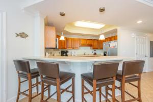 a kitchen with a counter with chairs around it at Phoenix on the Bay 1528 in Orange Beach