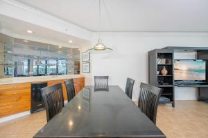 a dining room with a black table and chairs at Phoenix on the Bay 1528 in Orange Beach
