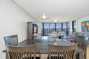 a dining room and living room with a table and chairs at Phoenix on the Bay 1528 in Orange Beach