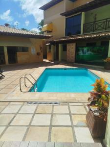 a swimming pool in front of a building at Condomínio Pousada Amarela 100 metros da Praia in Iguaba Grande