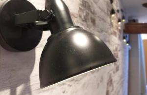 a black lamp hanging on a wall at Cocon industriel pour Nuits étoilées in Bourges