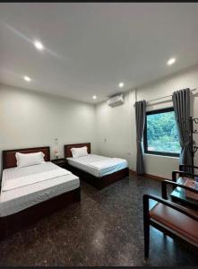a bedroom with two beds and a desk and a window at Bich Gian Trang An Hostel in Nguyên Ngoại