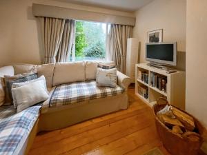 a living room with a couch and a tv at Garden View Cottage - Uk50886 in Cupar