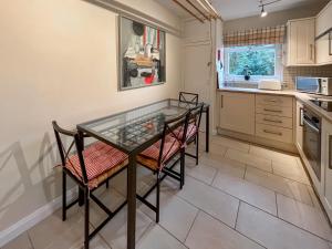 a kitchen with a glass table and chairs at Garden View Cottage - Uk50886 in Cupar