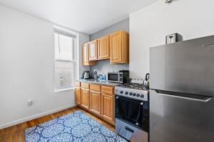 a kitchen with wooden cabinets and a stainless steel refrigerator at Hoboken Studio 15 Min from Manhattan in Hoboken