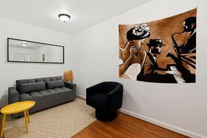 a living room with a couch and a painting on the wall at Hoboken Studio 15 Min from Manhattan in Hoboken