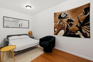a bedroom with a bed and a painting on the wall at Hoboken Studio 15 Min from Manhattan in Hoboken