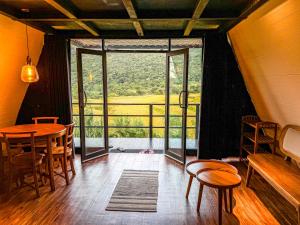 a room with a table and chairs and a large window at A frame Riverston in Matale