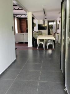a living room with a table and chairs on a tile floor at Tiny Black Loft in Port Vila