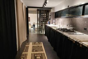 a kitchen with a long counter and a stove top oven at Tiny Black Loft in Port Vila