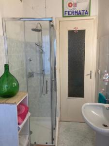 a bathroom with a glass shower with a sink at Sardinian tower house in Macomer +12 photos