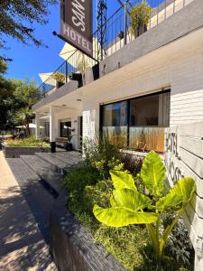 a building with plants in front of it at Hotel Centro SJ in Villa Carlos Paz