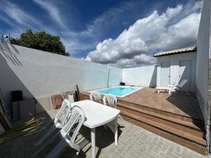 a patio with a table and chairs and a pool at Pousada Aconchego Mineiro in Aracaju