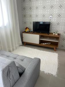 a living room with a couch and a flat screen tv at Pousada Aconchego Mineiro in Aracaju