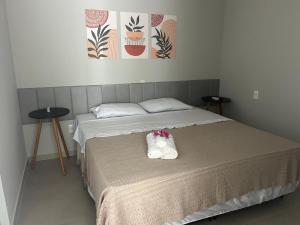 a bedroom with a bed with two shoes on it at Pousada Aconchego Mineiro in Aracaju