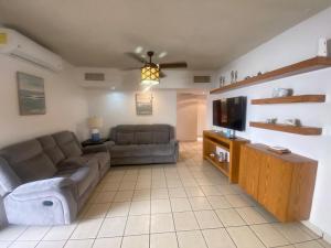 a living room with a couch and a flat screen tv at Villa Serena Erizos 2 in San Carlos