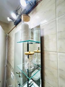 a glass shelf in a bathroom with white tiles at "Espacio Vélez" Nueva Córdoba -Allende-Oulton in Córdoba +25 photos
