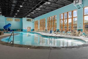 a large swimming pool in a building with tables and chairs at Timberline Hideaway with Hot Tub in Hollister