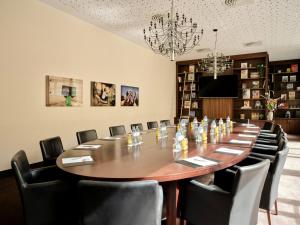 a conference room with a large wooden table and chairs at Flemings Hotel Wien-Stadthalle in Vienna