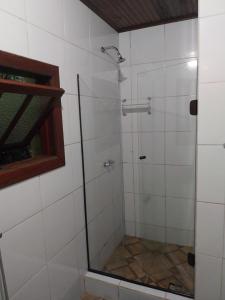 a shower with a glass door in a bathroom at Chalé Bosque Encantado Maringá MG in Itatiaia