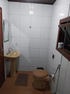 a bathroom with a toilet and a sink at Chalé Refúgio na Alameda Maringá MG in Bocaina de Minas