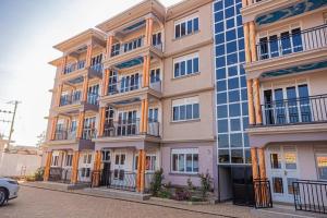 a largeartment building with a car parked in front of it at Alma Hotels Kampala in Kampala