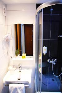 a bathroom with a sink and a shower at Parkhotel Bergheim in Bergheim
