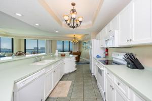 a kitchen with white cabinets and a view of the ocean at Phoenix on the Bay 1303 condo in Orange Beach