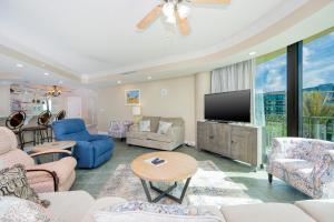 a living room with a couch and a tv at Phoenix on the Bay 1303 condo in Orange Beach +41 photos