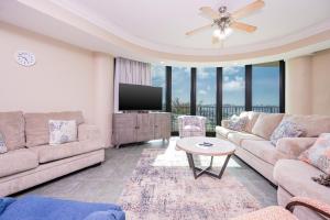 a living room with a couch and a tv at Phoenix on the Bay 1303 condo in Orange Beach