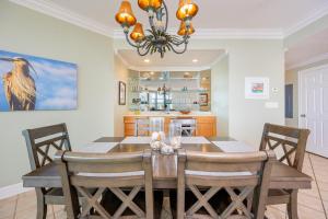 a dining room and kitchen with a table and chairs at Phoenix on the Bay 1405 in Orange Beach