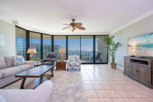 a living room with a couch and a tv at Phoenix on the Bay 1405 in Orange Beach +50 photos