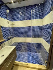 a blue tiled bathroom with a shower and a sink at CaSa FAMILY HOUSE in Casablanca +10 photos