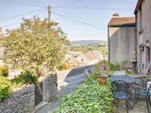 a table and chairs on the side of a house at Millstone Cottage in Bradwell +3 photos