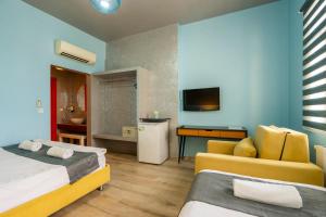 ein Zimmer mit zwei Betten, einer Couch und einem Fernseher in der Unterkunft cool cihangir in Istanbul