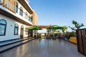 a courtyard of a building with green umbrellas at Max Home in Ninh Hải +24 photos