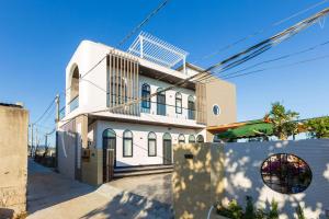 a white house with a fence in front of it at Max Home in Ninh Hải