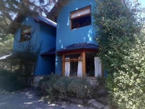 a blue house with a window on the side of it at Aromas de Montaña III in Junín de los Andes