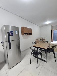 a kitchen with a table and a refrigerator at Apartamento completo - a 3 minutos do centro in Alta Floresta