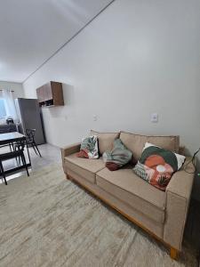 a couch with pillows on it in a living room at Apartamento completo - a 3 minutos do centro in Alta Floresta +25 photos