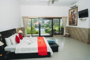 a bedroom with a large bed and a large window at Liberty Dive Resort in Tulamben