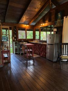 a kitchen with a table and a refrigerator at My Mountain Home - Le Chalet in Afaahiti