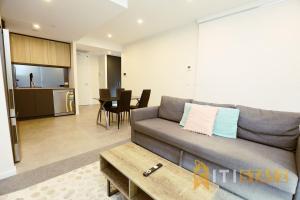 a living room with a couch and a table at Lovely in Lyneham - 1bd 1bth Apt in Canberra