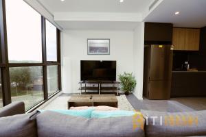 a living room with a couch and a tv at Lovely in Lyneham - 1bd 1bth Apt in Canberra