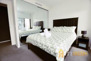 a bedroom with a large bed and a mirror at Lovely in Lyneham - 1bd 1bth Apt in Canberra