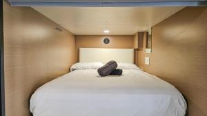 a large white bed in a small room at Seasun Hostel in Los Angeles